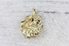 N7804Vintage 14K Yellow Gold Nugget Pendant Charm Retro Pretty LuxuryAMAZING SOLID 14KT GOLD PENDANT. GREAT NUGGET RAW DESIGN. WONDERFUL HIGHEST QUALITY. JUST PART OF MY MOST RECENT ESTATE FINDS! FOLLOW ME TO SEE THEM ALL! Brand: Metal: 14K Yellow GoldMaterial: Form: Nugget Pendant Charm Retro Pretty LuxurySize :3/4 x 1/2Age: VintageWeight (Grams): 5.5IT IS IN EXCELLENT ESTATE CONDITIONALL ITEMS LISTED AS  GOLD ARE EITHER MARKED AND OR TESTED FOR CONTENTTO HELP DETERMINE SIZE / SCALE OF PIECE TH 14k Stamped Yellow Gold Nugget Jewelry, Yellow Gold Nugget Brass Jewelry, Polished Yellow Gold Nugget Jewelry, 14k Yellow Gold Nugget Jewelry, Gold Nugget Jewelry As A Gift, Luxury Yellow Gold Nugget Jewelry, Gold Nugget Jewelry For Jewelry Making, Gold Hammered Nugget Necklace, Raw Design