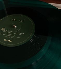 a green vinyl record sitting on top of a wooden table