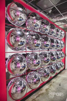 a red and white display case with chrome balls on the wall in front of it