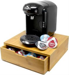 an espresso machine sitting on top of a wooden drawer