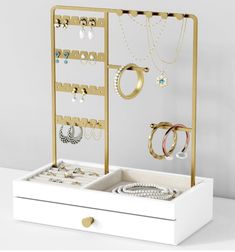 an open jewelry box with several pairs of rings and bracelets hanging from it's sides