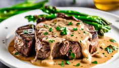 a white plate topped with steak covered in gravy and green asparagus