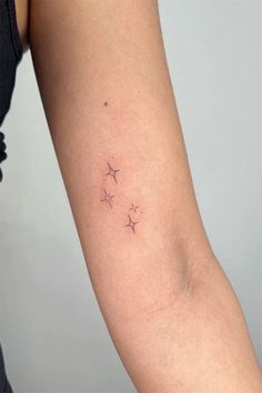 a woman's arm with three small stars on the back of her left arm