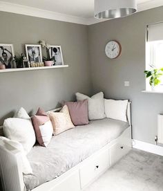 a living room filled with white furniture and lots of pillows on top of the couch