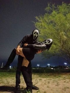 a man in a skeleton mask holding onto another person's leg