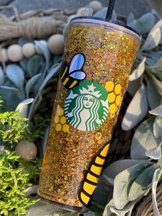 a starbucks cup with glitter and a bee on it