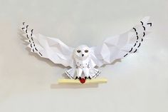 an origami owl sitting on top of a piece of paper with its wings spread