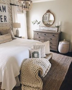 a white bed sitting in a bedroom next to a dresser