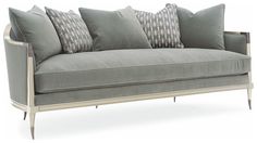 a gray couch with pillows on it and some silver trim around the armrests