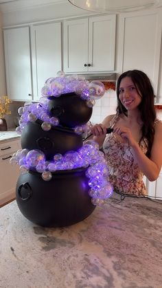 a woman standing in front of a snowman made out of balloons on top of a counter