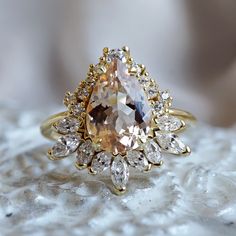 a fancy ring with an orange diamond surrounded by white and yellow diamonds on a marble surface