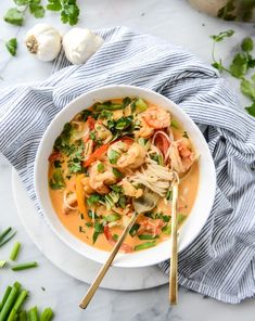 a white bowl filled with shrimp and vegetable soup