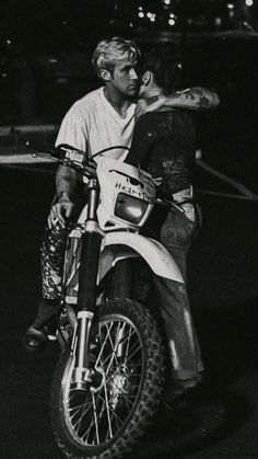 a man riding on the back of a motorcycle at night