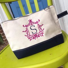 a white and black purse sitting on top of a green chair