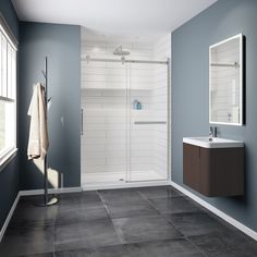 a bathroom with blue walls and gray tile flooring, including a walk in shower