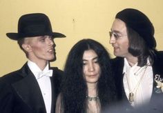 three people standing next to each other with long hair and wearing black hats on their heads