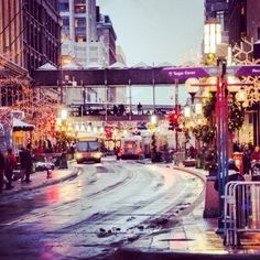 a city street is covered in snow and christmas lights