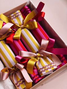 four wrapped gift boxes with ribbons in them