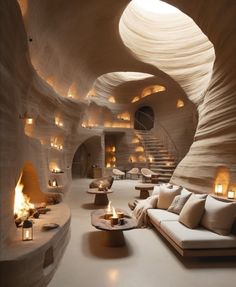 a living room filled with lots of furniture and lit candles on the floor next to a spiral staircase