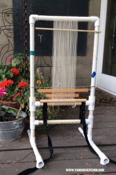 a chair made out of pipes sitting on top of a wooden floor next to flowers