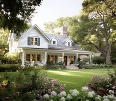 a white house surrounded by flowers and trees