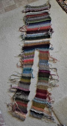 a pile of yarn sitting on top of a white carpet next to a rug and scissors