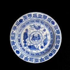 a blue and white plate on a black background