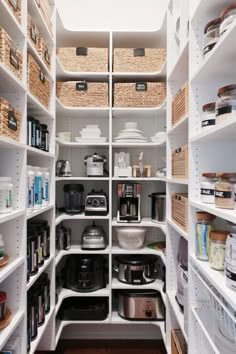 an organized pantry with white shelving and baskets