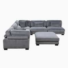 a large sectional couch with footstool and ottoman in grey fabric on an isolated white background