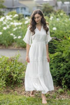 Unleash Your Inner Goddess with this Breathtaking White Maxi Dress Get ready to turn heads with this stunning white v-neck maxi dress. Perfect for any occasion, this dress is the epitome of elegance and grace. The short sleeves and white trim lace detailing add a touch of sophistication, making this dress a must-have for any fashion-forward woman. Imagine strolling down the beach in this dress, feeling the soft sand between your toes and the warm sun on your skin. You'll feel like a true goddess, radiating confidence and beauty. Or picture yourself at a fancy dinner party, stealing the show with your impeccable sense of style. Not only is this dress gorgeous, it's also incredibly The soft and flowy material will keep you cool and comfortable all day long, while the flattering silhouette wi Long White Flowy Dress, White Long Dress Summer, White Flowy Dress, Fancy Dinner Party, Short Sleeve Maxi Dress, Lace Trim Shorts, White Sundress, Floral Dress Casual, White Maxi Dress