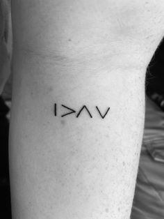 a person with a small tattoo on their arm that says vaki in black ink