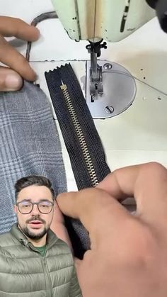 a man is working on a sewing machine with his hand over the top of it