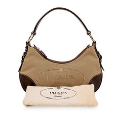 The Prada Canvas Tessuto bag?ÿis a small, classic hobo?ÿshoulder bag, perfect for everyday use. Adorned with the iconic logo print featured on the base of the bag and contrasting dark brown leather features, the tessuto hobo?ÿis perfect for daytime casual use ƒ?? a great bag to grab on the go. With the classic neutral brown tones in both canvas and leather, Prada?ÿhave crafted a?ÿperfect functional bag for casual daytime use.?ÿ SPL Exterior Light brown canvas Dark brown leather trimming, piping and bow on front Leather shoulder strap Silver hardware features Zip top closure Good condition -?ÿBag has been extremely well kept with the exception of a few light marks and some minor scratches to the brown leather trims Interior Brown fabric lining with Prada interwoven in print On open compartm Iconic Logo, Brown Tones, Brown Fabric, Vintage Canvas, Brown Canvas, Timeless Handbag, Dark Brown Leather, Luxe Fashion, Bags Designer Fashion