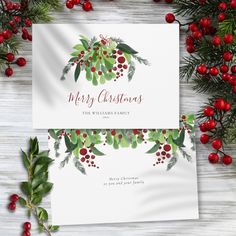 two christmas cards with holly leaves and berries on them, next to red berry garlands