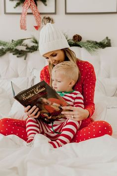 a woman reading a book to a child on the bed with christmas decorations in the background