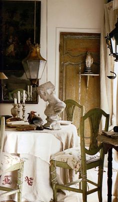 a statue sitting on top of a table next to a white table cloth covered chair