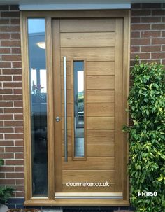 a wooden door sitting next to a brick wall and potted planter in front of it