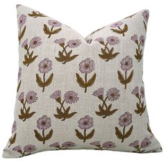 a white pillow with pink and brown flowers on the front, sitting against a white background