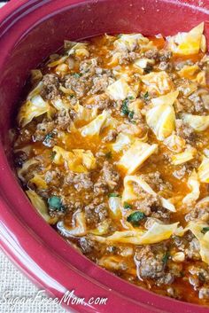 a red bowl filled with pasta and meat