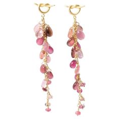 Gorgeous pair of 18k gold drop earrings with sumptuous, crystal clear pink tourmaline beads cascading down like a bunch of pink grapes creating lots of movement. A quirky "knot" neatly covers the earlobe. A mesmerising piece of jewelry that lends an organic and earthy vibe to your summer outfit. About tourmaline: it is a popular gemstone due to its unique beauty and variety of colors. It comes in a wide range of colors, including pink, green, blue, yellow, red, and multi-color. It is a durable g Pink Beads Earrings, Pink Beaded Earrings, Cascade Earrings, Beaded Stuff, Mohs Scale, Tourmaline Earrings, Blue Yellow Red, Tourmaline Beads, Knot Earrings