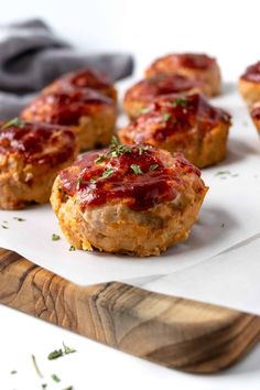 mini meat patties with ketchup and parsley on a wooden cutting board