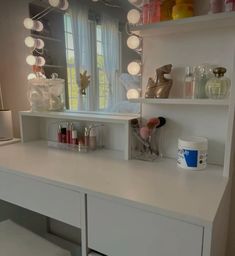 a white desk topped with lots of drawers and lights on top of it next to a window