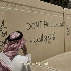 a man writing graffiti on the side of a wall with words written in different languages