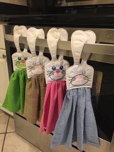 towels hanging from the oven rack in front of an oven with bunny ears on them