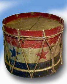 an old wooden drum with stars painted on the side and rope wrapped around it's sides