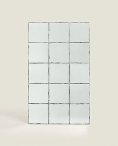 a white square mirror with black lines on it