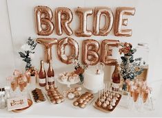 a table topped with lots of balloons and desserts next to a sign that says bride to be