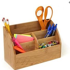 a wooden desk organizer with scissors, pens and other office supplies in the bottom compartment