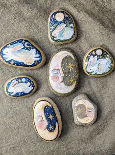 six painted rocks sitting on top of a blanket