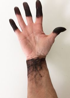 a person's hand with black marks on it